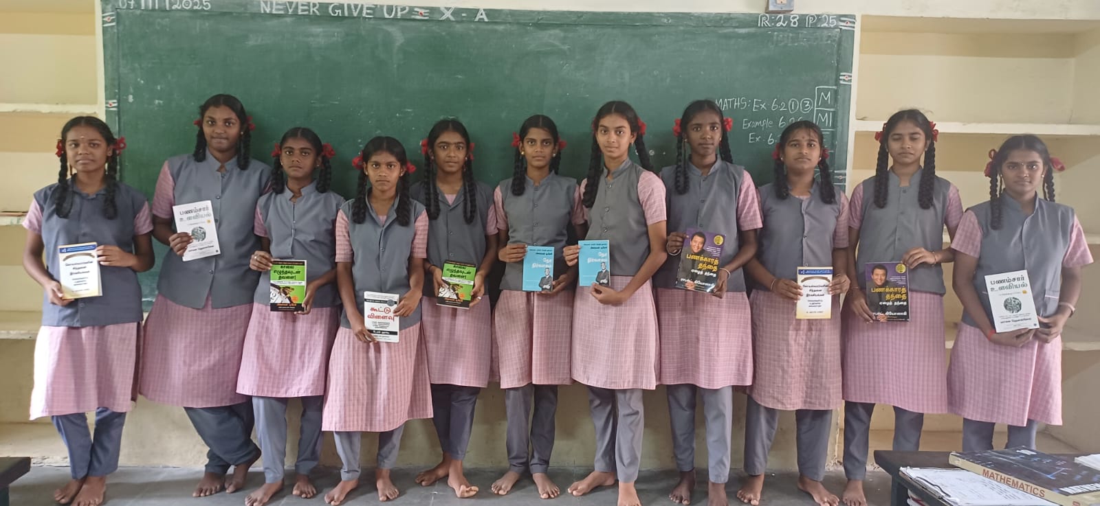 Students holding financial literacy books in classroom